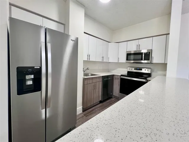 a kitchen with stainless steel appliances granite countertop a refrigerator stove and microwave