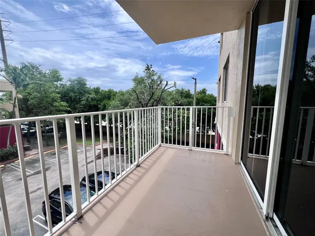 a view of balcony with wooden floor and fence