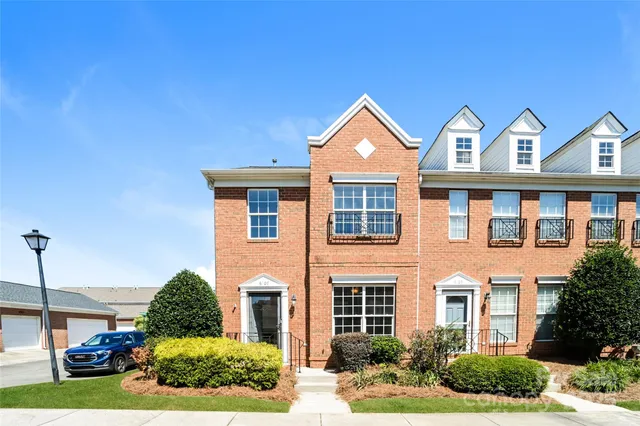 a front view of a residential houses with yard and parking space