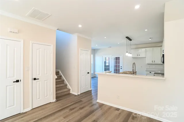 a large kitchen with a lot of counter space and wooden floor