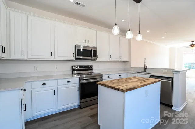 a kitchen with stainless steel appliances granite countertop a sink a stove and a granite counter tops