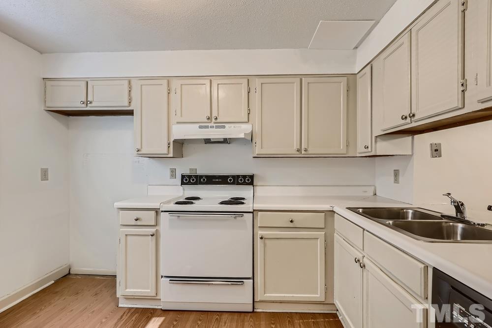 7702 Ohmann Court Raleigh, NC 27615 - Photo 12 of 28 a kitchen with white cabinets stainless steel appliances and sink