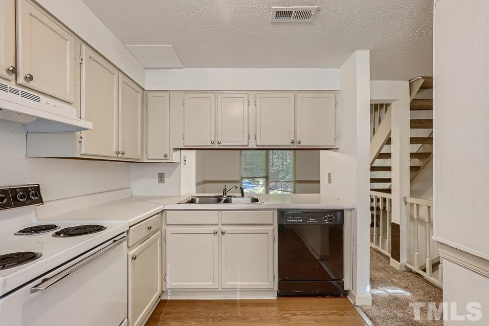 7702 Ohmann Court Raleigh, NC 27615 - Photo 13 of 28 a kitchen with a sink stove and cabinets