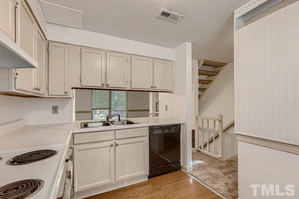 7702 Ohmann Court Raleigh, NC 27615 - Photo 14 of 28 a kitchen with a sink cabinets and appliances