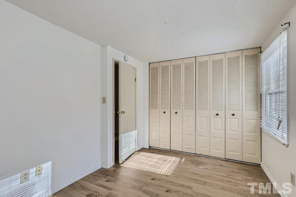 7702 Ohmann Court Raleigh, NC 27615 - Photo 21 of 28 a view of an empty room with wooden floor