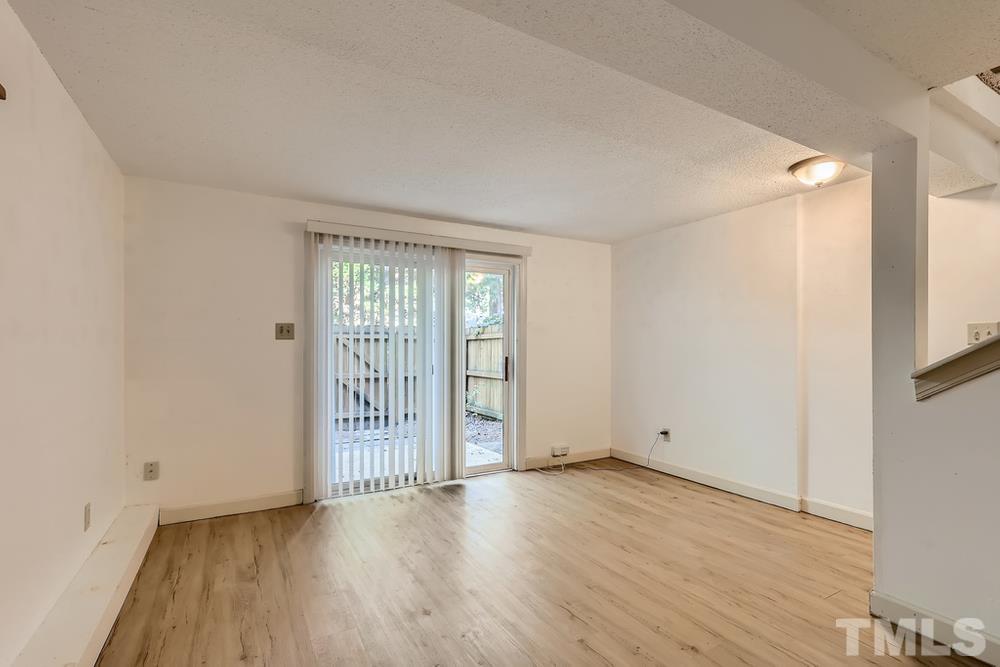 7702 Ohmann Court Raleigh, NC 27615 - Photo 23 of 28 an empty room with wooden floor and windows
