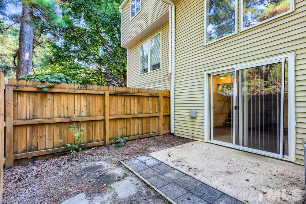 7702 Ohmann Court Raleigh, NC 27615 - Photo 25 of 28 a view of a house with a wooden floor roof and floor to ceiling window