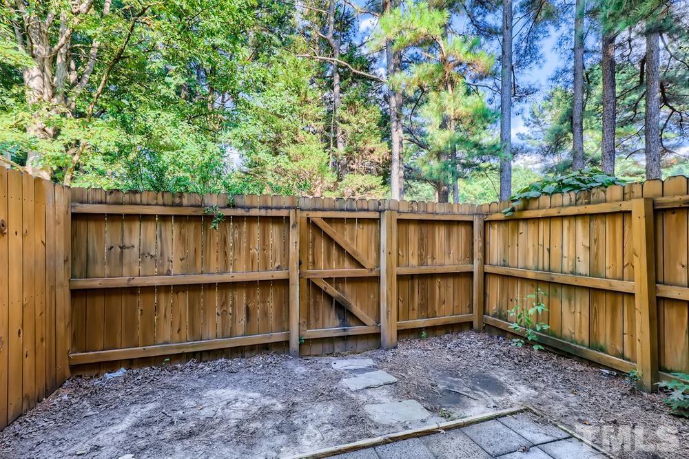 7702 Ohmann Court Raleigh, NC 27615 - Photo 26 of 28 a backyard of a house with wooden deck and outdoor seating