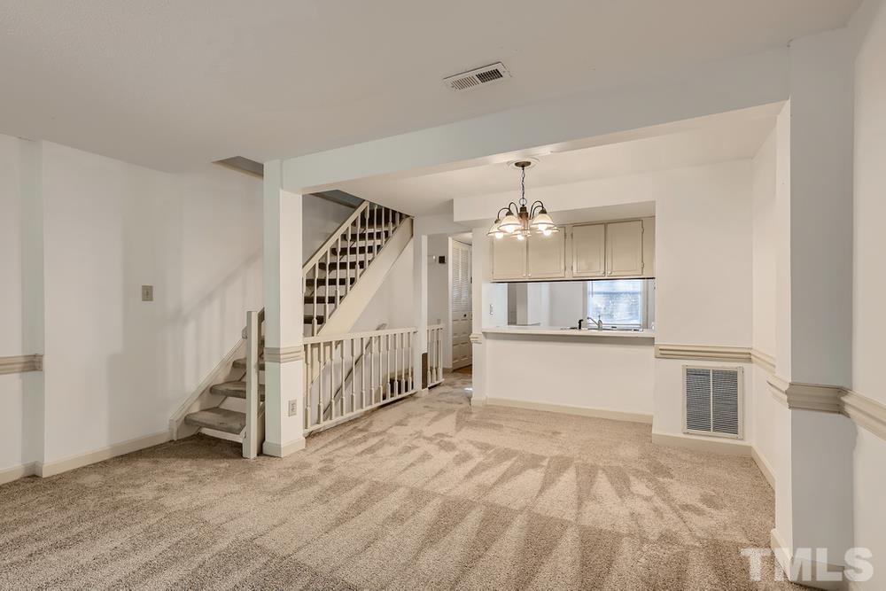 7702 Ohmann Court Raleigh, NC 27615 - Photo 6 of 28 a view of an empty room with stairs and a window