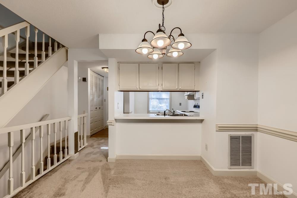 7702 Ohmann Court Raleigh, NC 27615 - Photo 8 of 28 a view of a hallway with chandelier