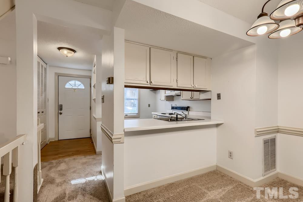 7702 Ohmann Court Raleigh, NC 27615 - Photo 9 of 28 a kitchen with stainless steel appliances granite countertop a refrigerator and a stove
