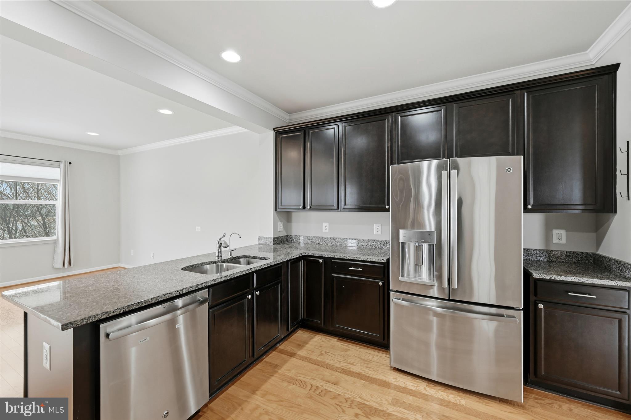 151 Brasstown Loop Stephenson, VA 22656 - Photo 22 of 88 a kitchen with a sink a refrigerator and wooden cabinets
