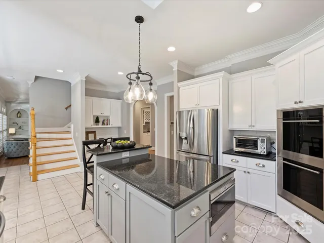 a kitchen with stainless steel appliances granite countertop a sink refrigerator and cabinets