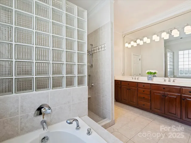 a bathroom with a double vanity sink a mirror and a shower