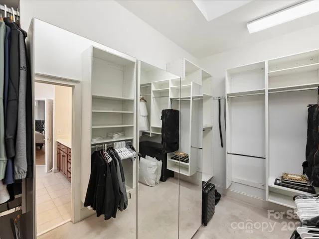a walk in closet with wooden floor and furniture