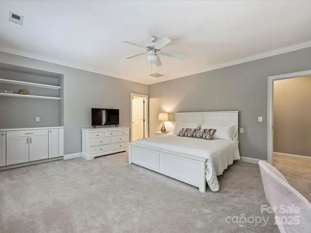 a spacious bedroom with a bed and a flat screen tv