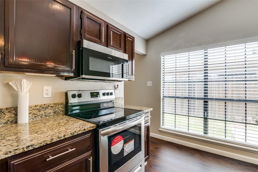 4430 Chapman Street The Colony, TX 75056 - Photo 11 of 24 a kitchen with stainless steel appliances granite countertop a stove and a microwave