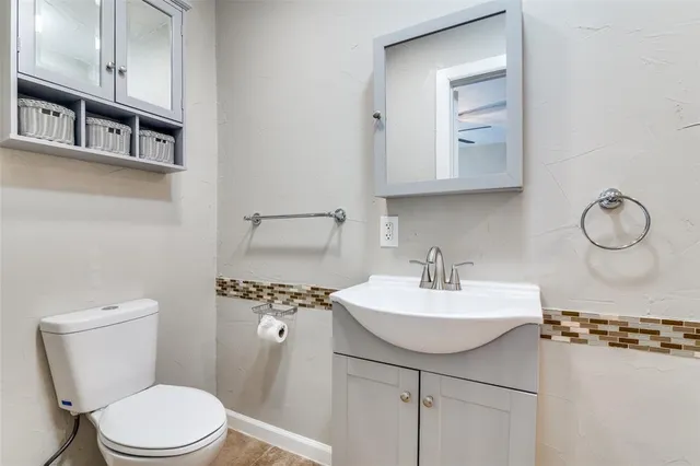 a bathroom with a sink toilet and mirror