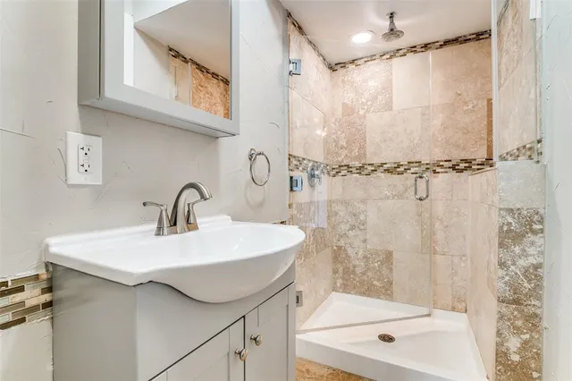 a bathroom with a sink a mirror a bathtub and shower