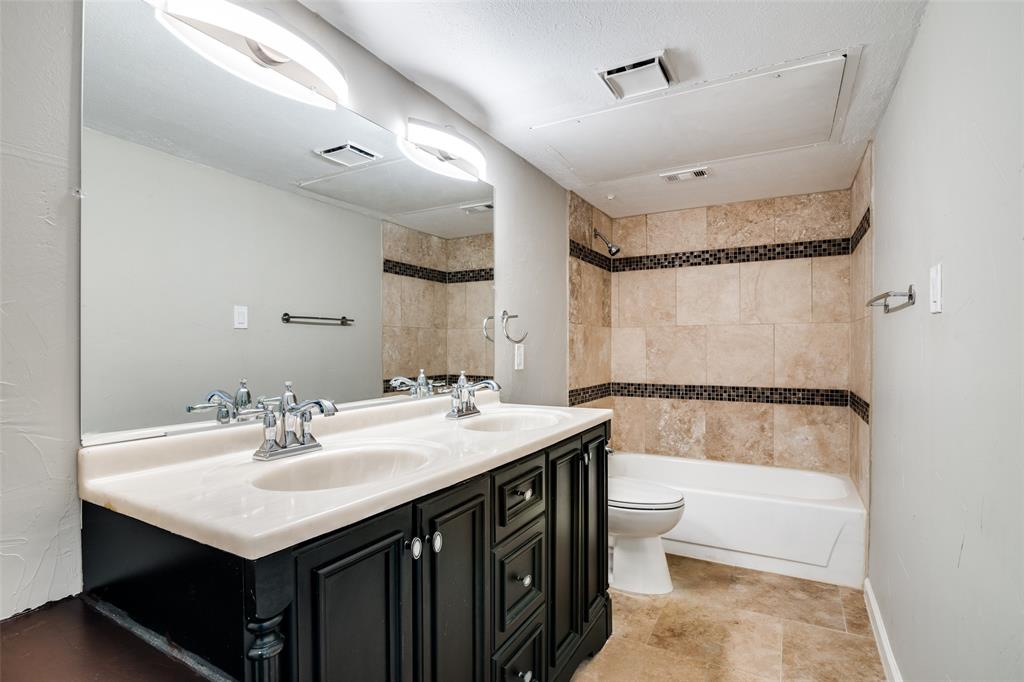 4430 Chapman Street The Colony, TX 75056 - Photo 21 of 24 a bathroom with a sink a toilet a mirror and shower