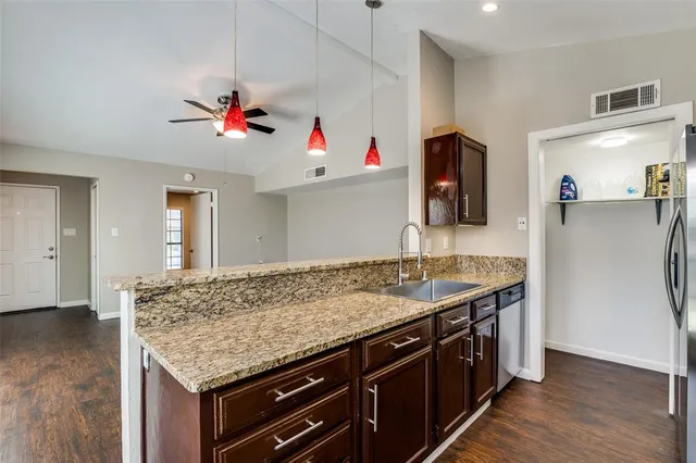 a bathroom with a granite countertop sink and a refrigerator