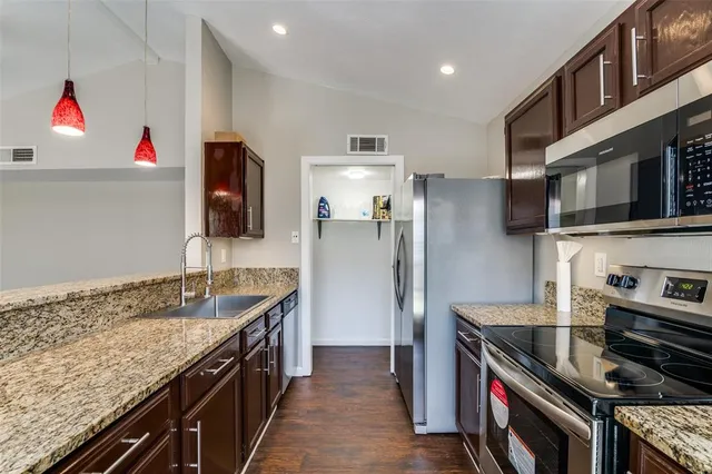 a kitchen with stainless steel appliances granite countertop a sink stove and refrigerator