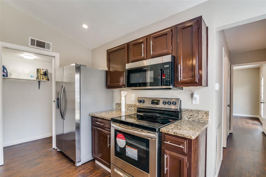 4430 Chapman Street The Colony, TX 75056 - Photo 9 of 24 a kitchen with stainless steel appliances a stove microwave and refrigerator