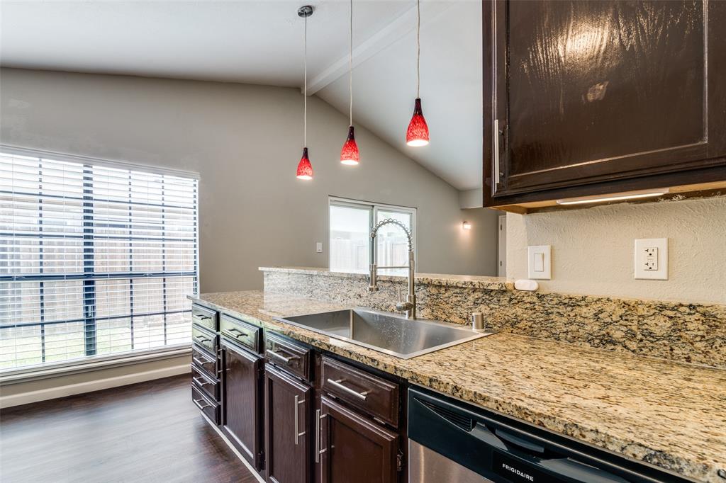 4430 Chapman Street The Colony, TX 75056 - Photo 10 of 24 a kitchen with granite countertop sink and cabinets