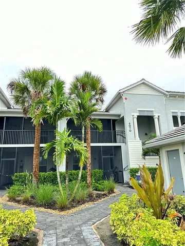 a front view of a house with a yard and potted plants