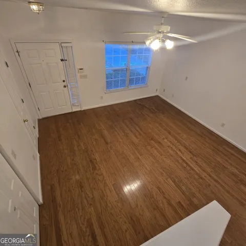 a view of an empty room with wooden floor