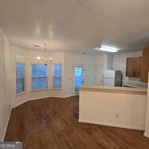 a living room with hard wood floors and a kitchen