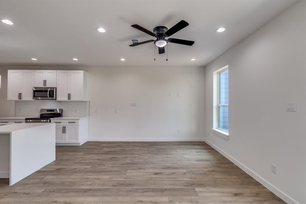 2427 Merlin Street Dallas, TX 75215 - Photo 11 of 24 a view of a kitchen with a sink and dishwasher a refrigerator with wooden floor