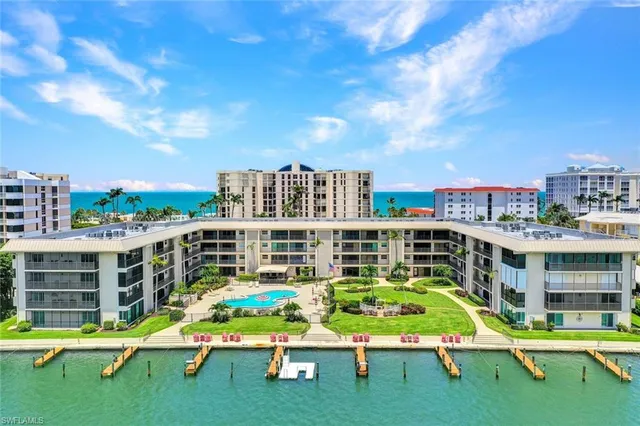 a view of pool with lawn chairs and iron fence