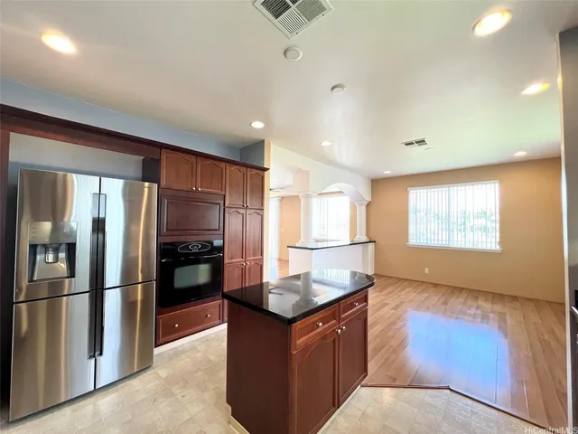 a kitchen with stainless steel appliances granite countertop a refrigerator a sink and a stove