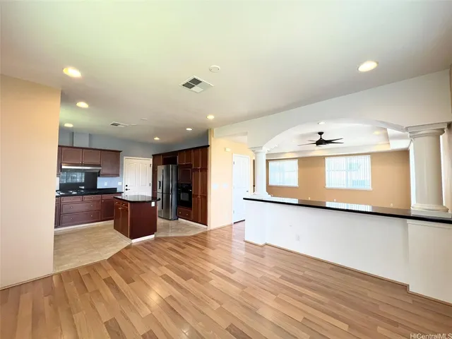 a large kitchen with stainless steel appliances kitchen island a large counter top and a wooden floors