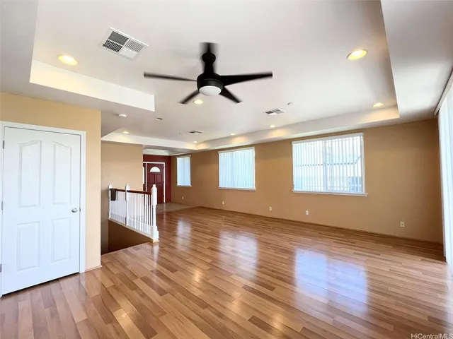 a view of an empty room with window and wooden floor
