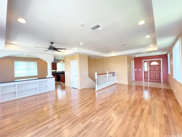 a view of an empty room with window and wooden floor