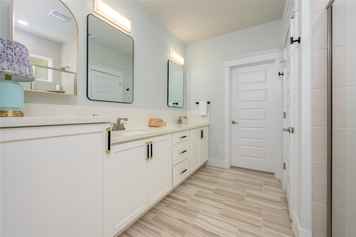 142 Volterra Lane Dripping Springs, TX 78620 - Photo 11 of 37 a spacious bathroom with a double vanity sink a mirror and a shower