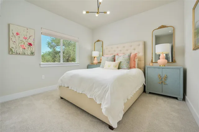 a bedroom with a bed painting on wall and a window
