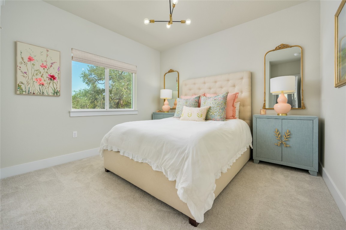 142 Volterra Lane Dripping Springs, TX 78620 - Photo 18 of 37 a bedroom with a bed painting on wall and a window