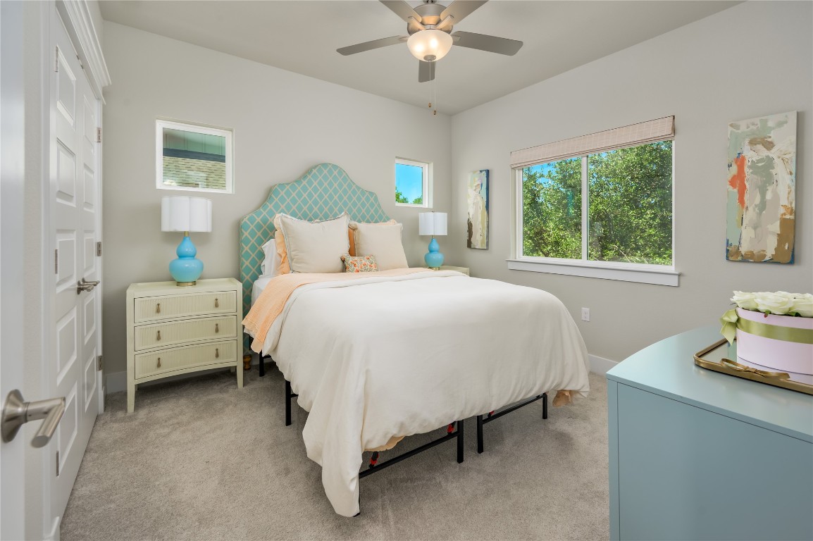 142 Volterra Lane Dripping Springs, TX 78620 - Photo 19 of 37 a bedroom with a bed and a chandelier