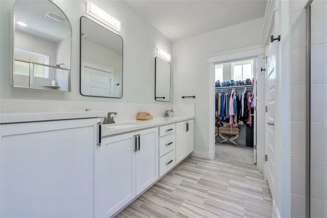 a spacious bathroom with a double vanity sink and a mirror