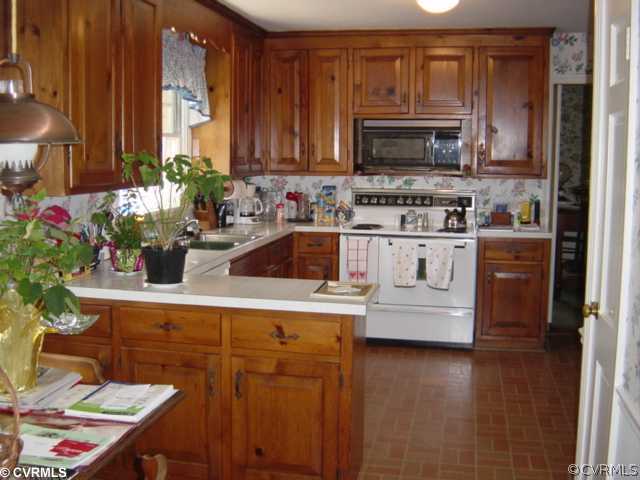 301 Ralston Road Henrico, VA 23229 - Photo 5 of 9 a kitchen with stainless steel appliances a sink a stove a microwave a sink cabinets and wooden floor