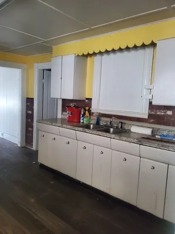 a kitchen with granite countertop a stove and a wooden cabinets