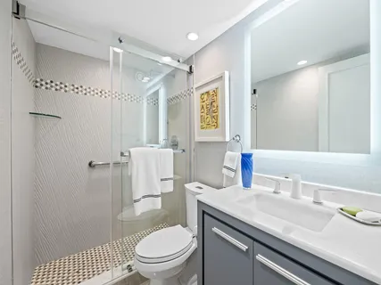 a bathroom with a granite countertop toilet sink and shower