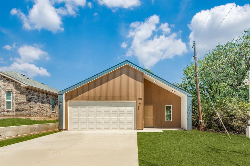 1563 Milam Street Fort Worth, TX 76112 - Photo 1 of 12 View of front of property featuring a garage, a front lawn, and concrete driveway