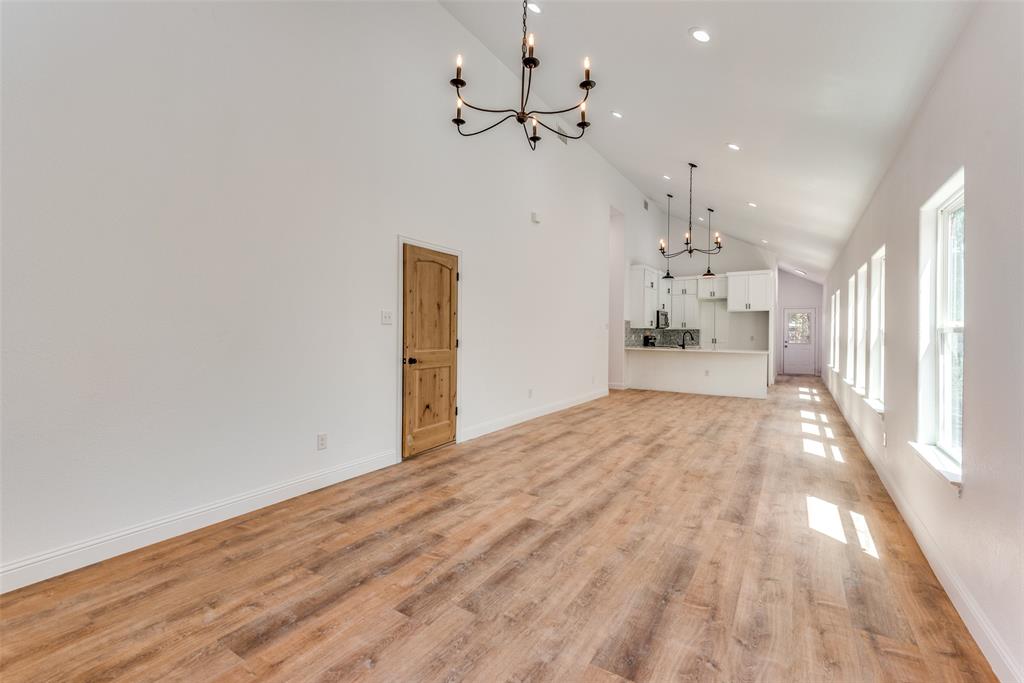 1563 Milam Street Fort Worth, TX 76112 - Photo 2 of 12 Unfurnished living room featuring a chandelier, high vaulted ceiling, recessed lighting, and light wood-type flooring