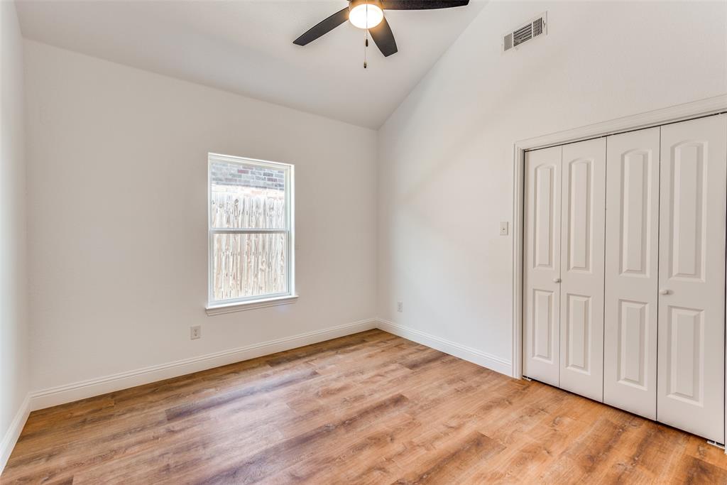 1563 Milam Street Fort Worth, TX 76112 - Photo 7 of 12 Unfurnished bedroom with light wood-style flooring, lofted ceiling, a closet, and ceiling fan