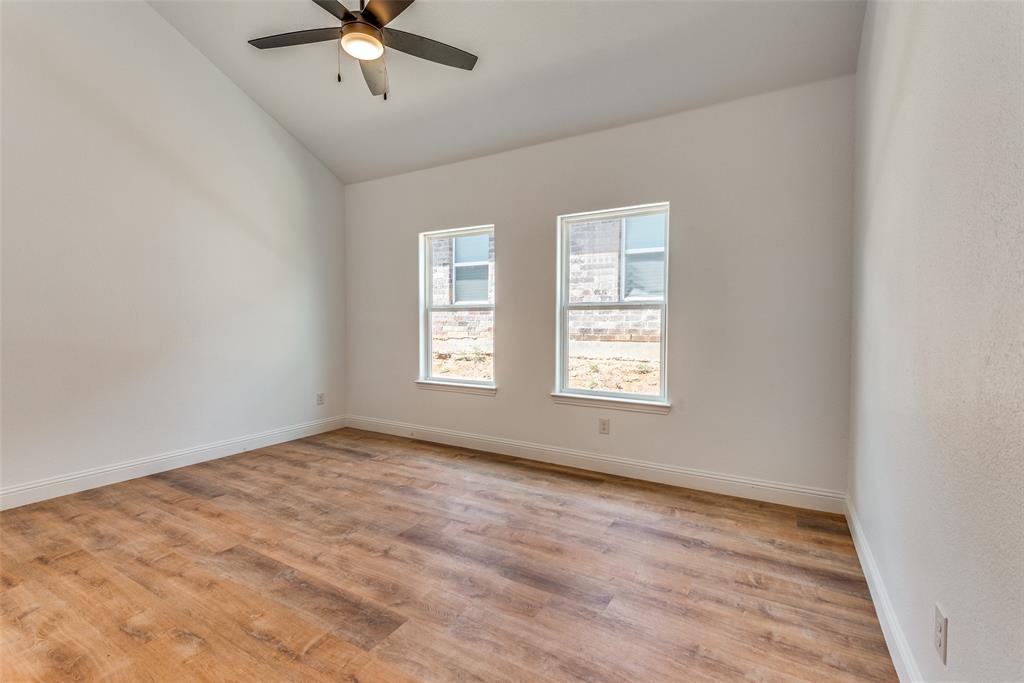 1563 Milam Street Fort Worth, TX 76112 - Photo 10 of 12 Spare room featuring light wood-style floors, lofted ceiling, and a ceiling fan