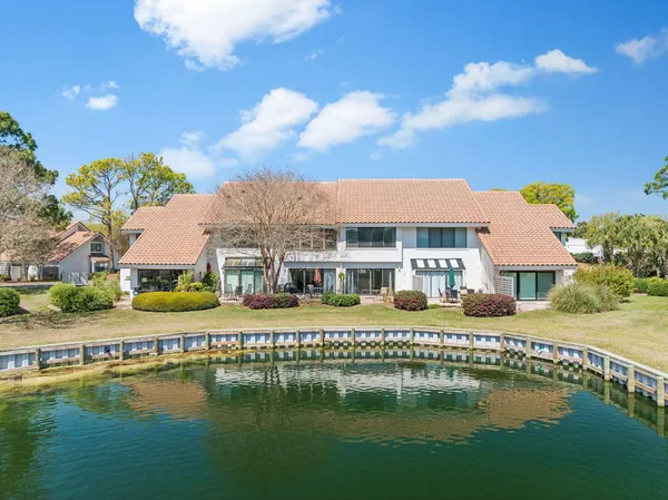 an aerial view of residential houses with outdoor space and lake view